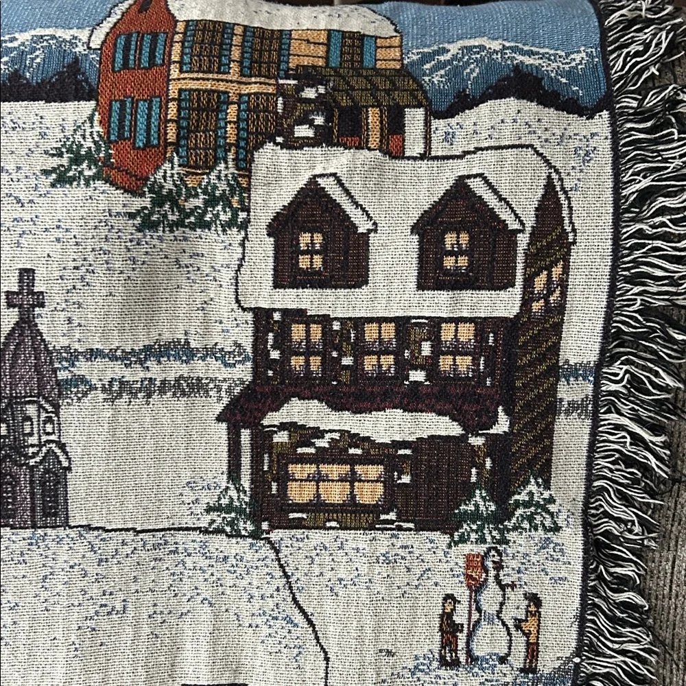 woven tapestry throw blanket featuring a winter village scene fringe edges